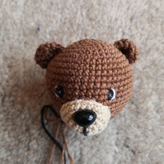 Amigurumi maci feje horgolt fülekkel, fekvő nézetben