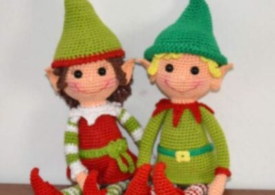 Amigurumi karácsonyi manó pár sapkában és ünnepi ruhában, zöld és piros színekben horgolva.